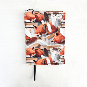 Een boekhoes met een slapende vos op een boek.