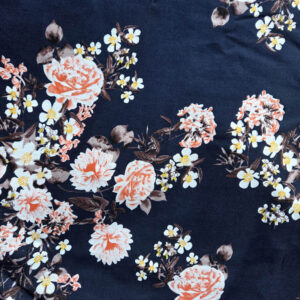 Een stof gemaakt van katoen. De achtergrond is donkerblauw en er staan zalmkleurige bloemen op.
