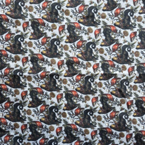 Een stof gemaakt van katoen. Er staat een patroon op van heksenhoedjes en paddenstoelen. De achtergrond is wit.