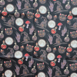 Deze stof is gemaakt van katoen. Het patroon is heksenhoedjes & paddenstoelen op zwart.