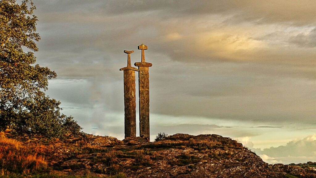 Twee zwaarden die uit een rots steken tijdens de zonsondergang