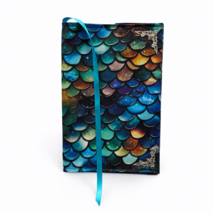 Boekenhoes - Drakenschubben is een boekenhoes met een katoenen stof die verschillende drakenschubben erop heeft. Hij is hoofdzakelijk blauw met bruin en groene accenten.