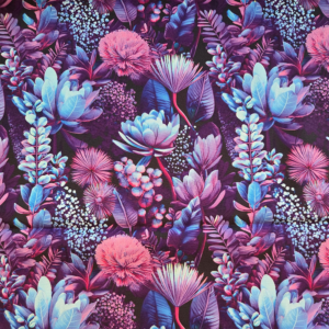 Dit is een gladde katoenen stof van donkerblauw met paarse en knalblauwe elementen erop, zoals bloemen en takjes. Het doet Indonesisch aan.