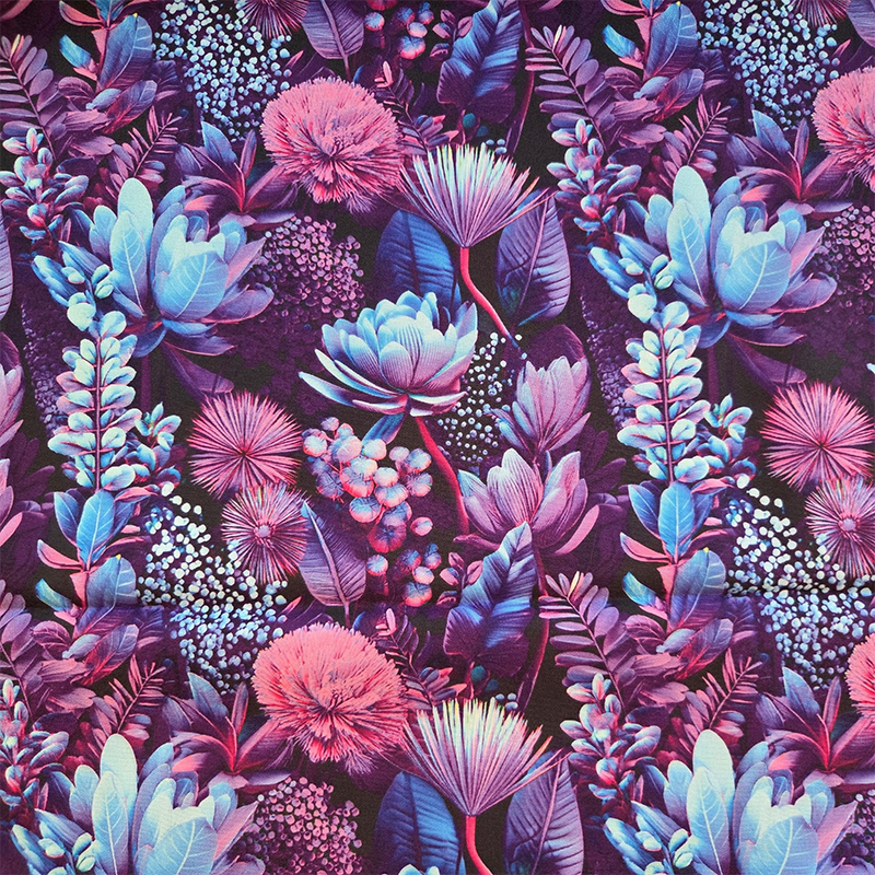 Dit is een gladde katoenen stof van donkerblauw met paarse en knalblauwe elementen erop, zoals bloemen en takjes. Het doet Indonesisch aan.