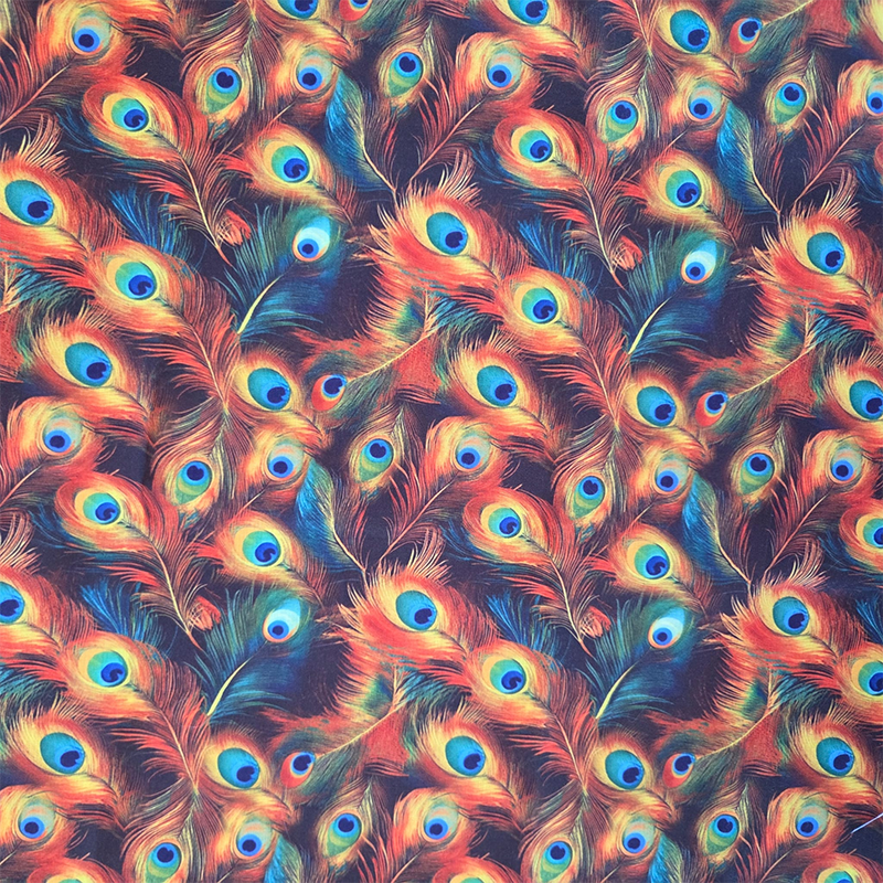 Een katoenen stof met oranje pauwenveren erop afgebeeld.