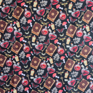 Rode toverdrankjes op een zwarte achtergrond met boeken en kaarsen. De stof is gemaakt van katoen.